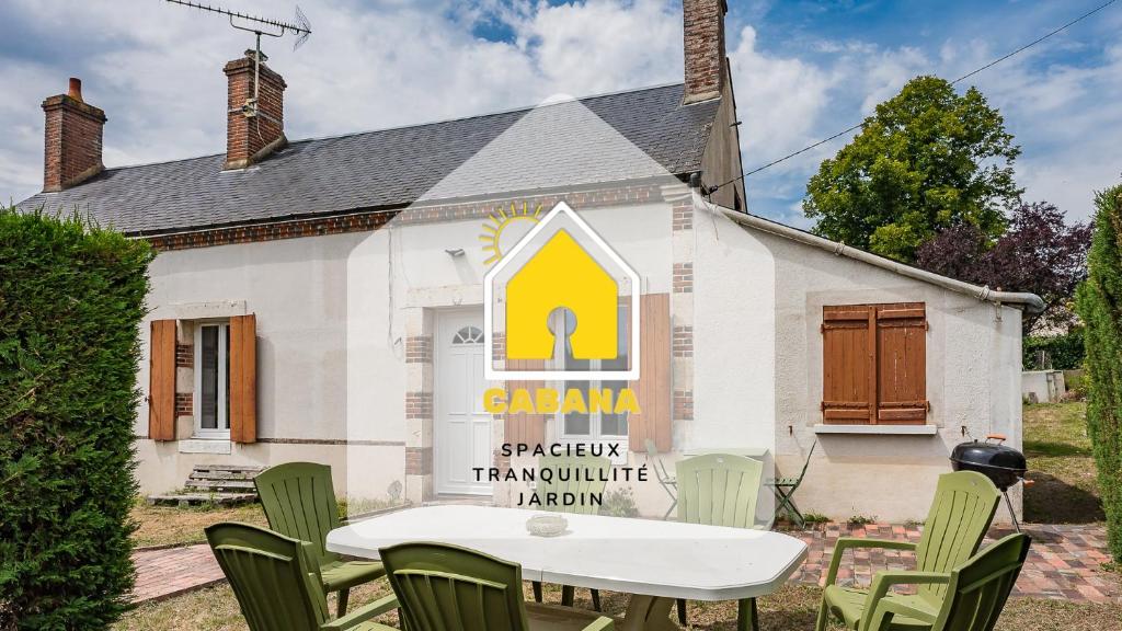 una casa con un tavolo e sedie di fronte di CABANA & LES PORTES DE LA FORÊT D' ORLÉANS a Nevoy