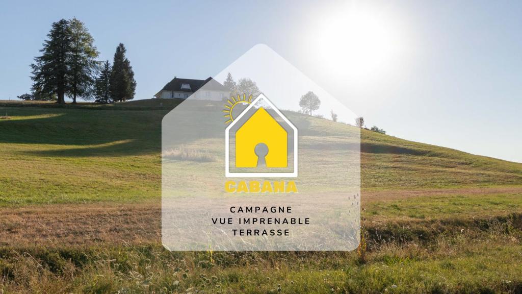 ein Schild in der Mitte eines Feldes mit einem Haus in der Unterkunft CABANA & La Villa sur la Colline - Au Calme 