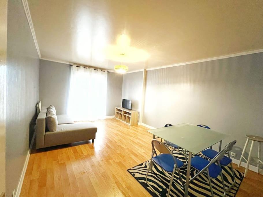 a living room with a table and chairs and a couch at Disney et Paris pour 4 personnes RER A in Champs-sur-Marne