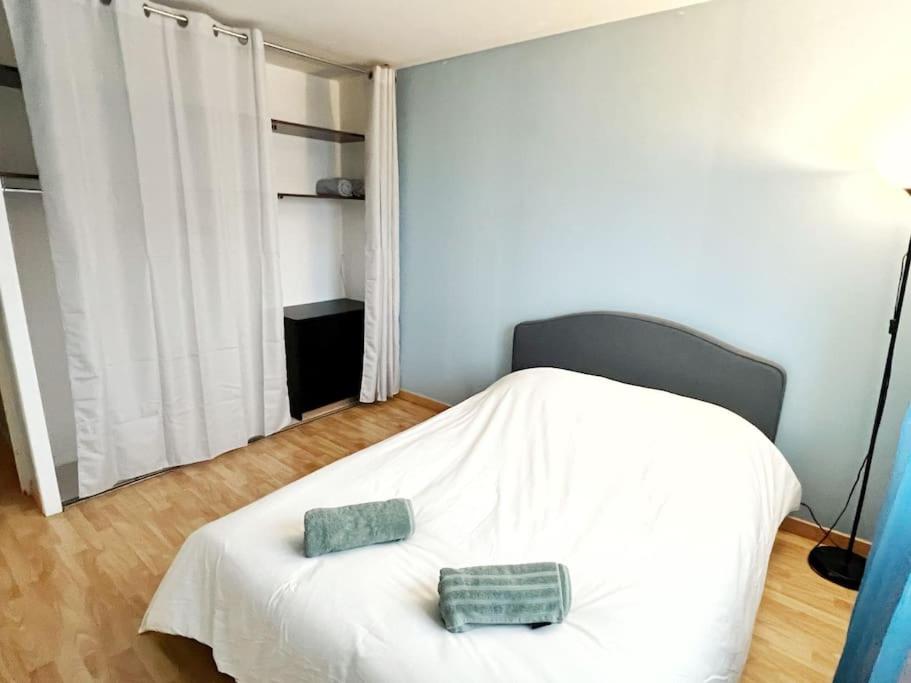 a bedroom with a white bed with two pillows on it at Disney et Paris pour 4 personnes RER A in Champs-sur-Marne