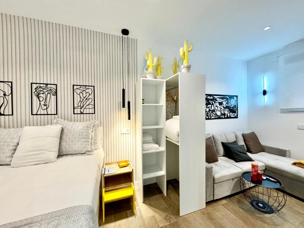 una camera con un letto bianco e un divano di Luxury private Flat City Center, AC & Parking gratuito a Madrid