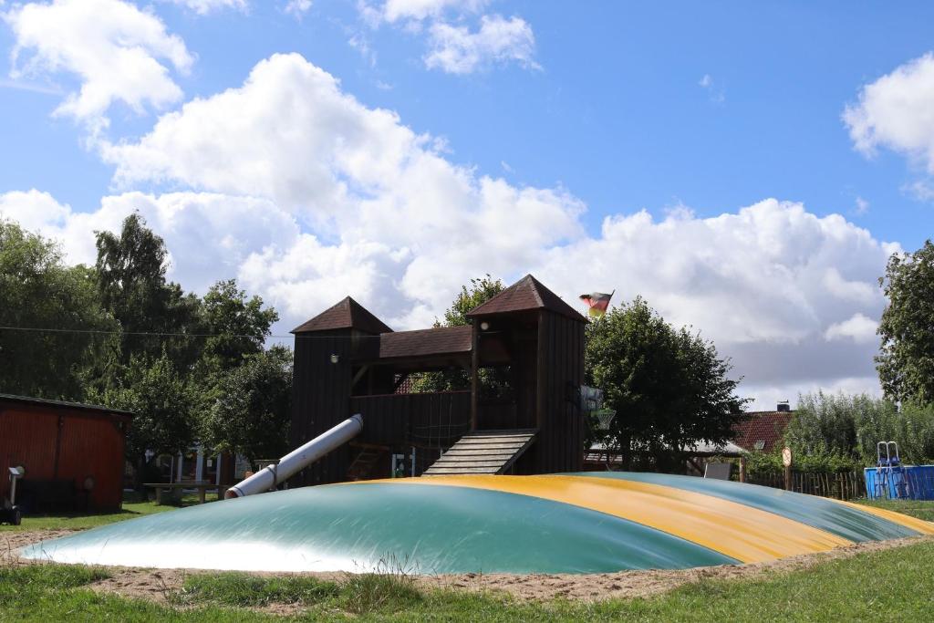 a playground with a slide in a park at Ferienhaus II Blumenwiese in Schwienkuhl an der Ostsee-für 10 Pers Sauna-Whirlwanne Ostsee in Schwienkuhl