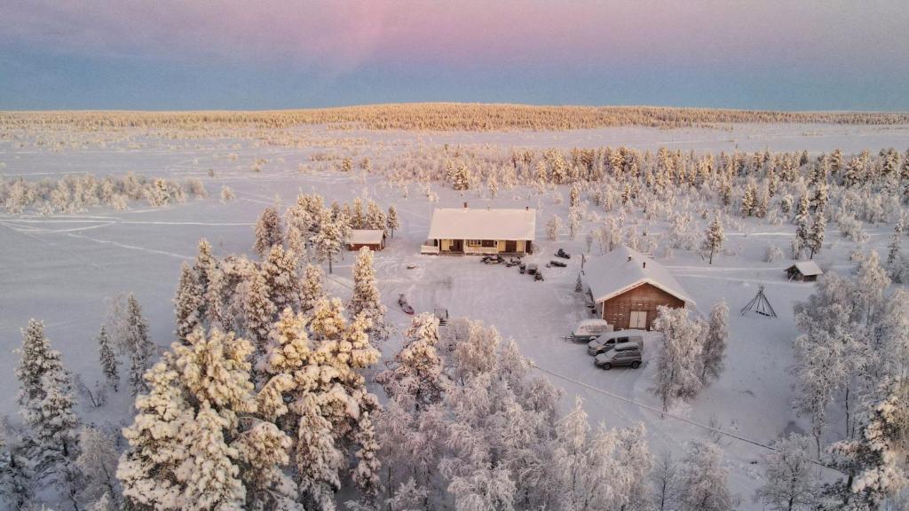 NunnanenにあるMajoitus Valkeaの雪に覆われた森の中の小屋の空中風景