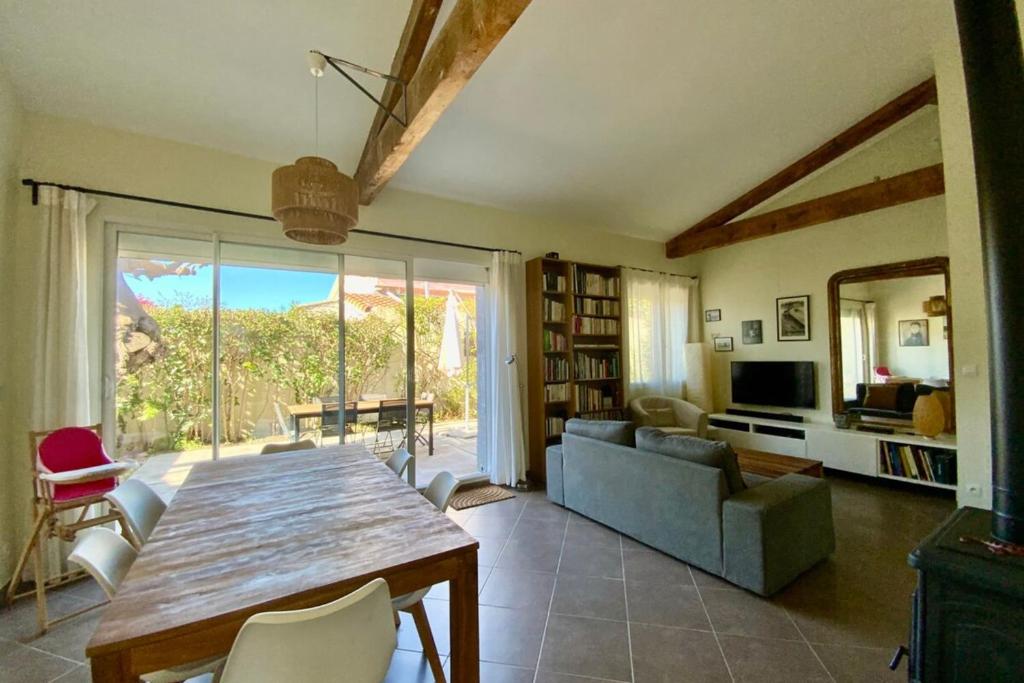 a living room with a wooden table and a couch at La Poétique - Air-conditioned house with 3 bedrooms! in Montpellier