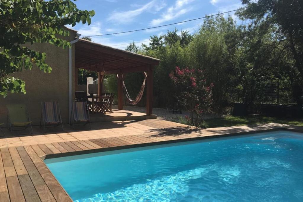 une piscine dans une cour avec un patio dans l'établissement GROOMI La Gardoise- Villa swimming pool and pétanque court!, à Moulézan