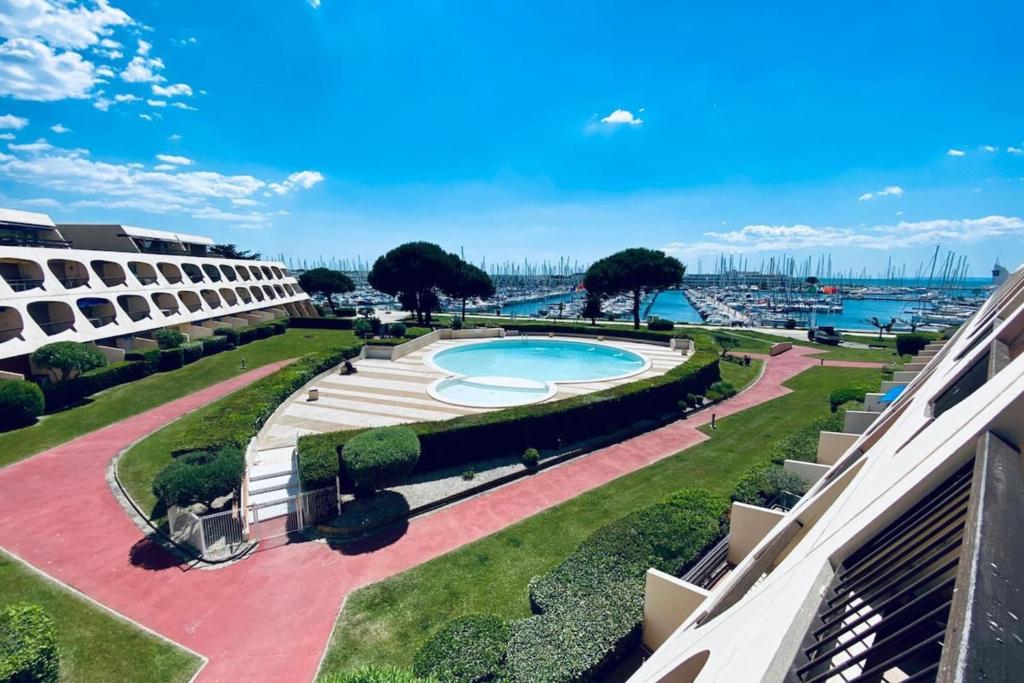 a view of a swimming pool from a building at Le Port Camargue- 2 bedrooms and air-conditioned ! in Le Grau-du-Roi