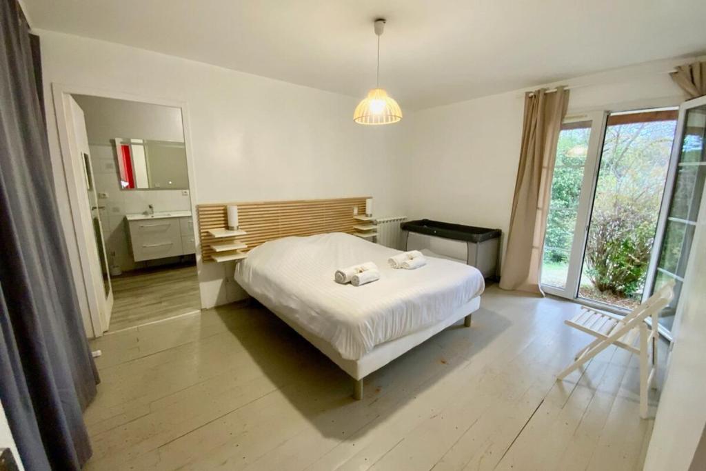 a bedroom with a bed with two towels on it at La Bucolique-Villa in the heart of greenery! in Saint-Jean-de-Védas