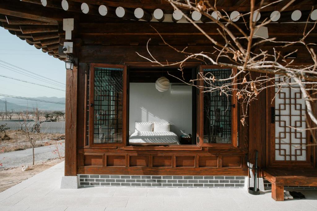 a building with a window with a bed in it at Hanok Stay SungHyeDang in Gyeongju