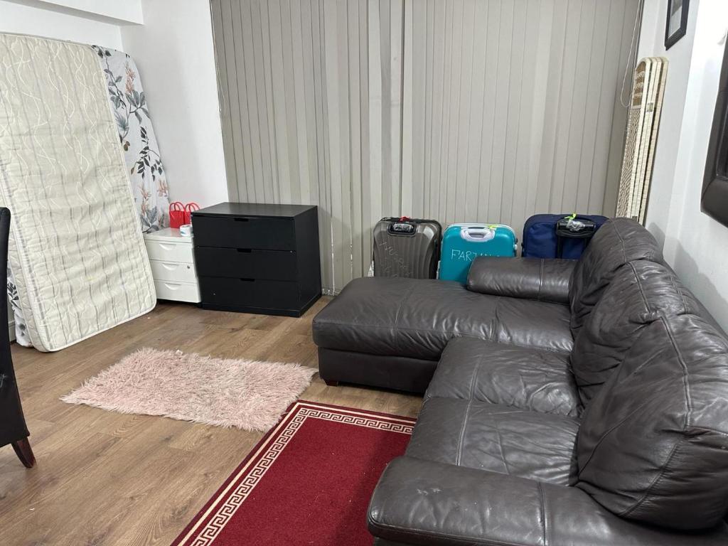 a living room with a leather couch and a rug at Captivating 1-Bed Apartment in London in London
