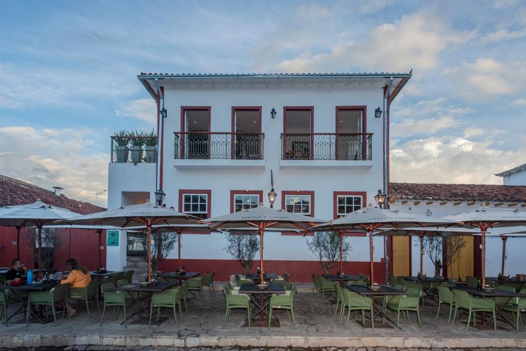 a group of tables and umbrellas in front of a building at Casa da Praça 43 in Tiradentes