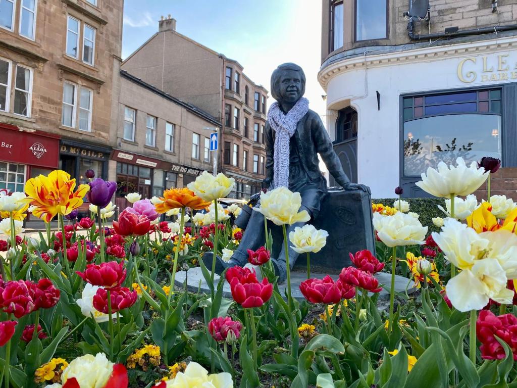 a statue of a woman sitting in a field of flowers at The Wheelhouse, Gourock in Gourock