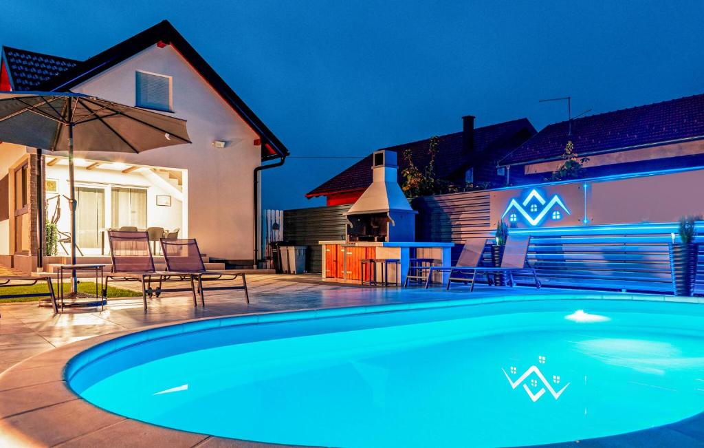 une piscine avec une table, des chaises et un parasol dans l'établissement Gorgeous Home In Varazdin Breg, à Varaždin Breg