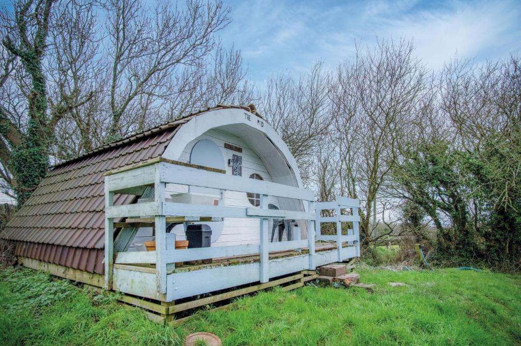 une petite maison avec un toit sur un champ dans l'établissement The Pod - 1 Bedroom - Freshwest Beach Retreat, à Pembroke