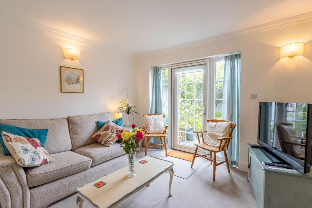 ein Wohnzimmer mit Sofa und Fernseher in der Unterkunft The Old Bakery in Southwold