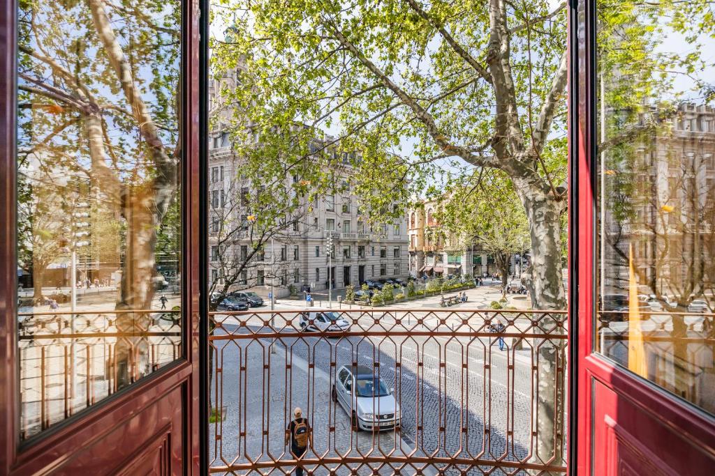 een uitzicht vanuit een raam van een straat met een auto bij Casa Trindade Apartments in Porto