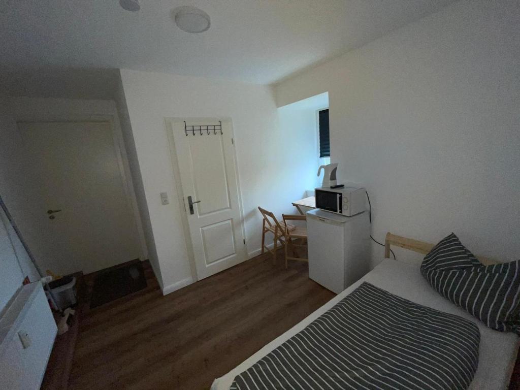een kleine kamer met een bed en een magnetron. bij Goldfisch-1-Person in Brunsbüttel
