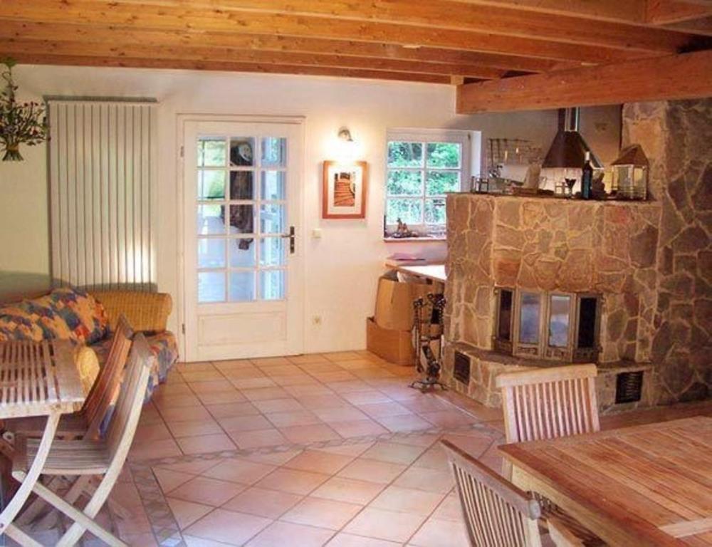 sala de estar con chimenea de piedra y mesa en Ferienhaus für 7 Personen und 1 Kind in Blankenheim, Eifel, en Blankenheim