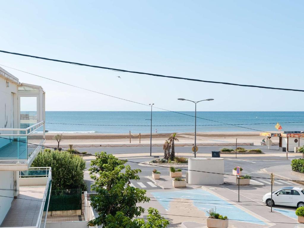 une vue sur la plage depuis le balcon d'un immeuble dans l'établissement Studio cabine à 20m de la plage avec balcon et parking à Narbonne-Plage - FR-1-409-140, à Narbonne