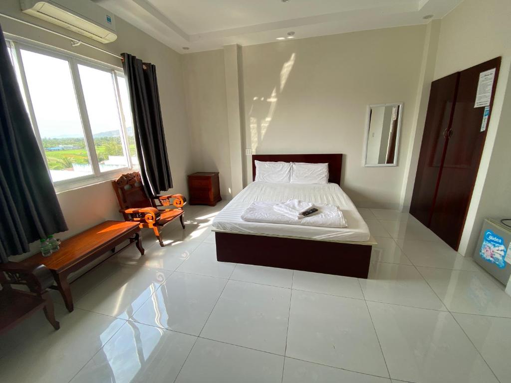 1 dormitorio con 1 cama y 1 silla en Phong Lan Guesthouse, en Chau Doc