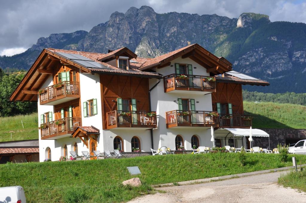 una casa con balcones y una montaña en el fondo en Agriturismo Pianrestel, en Cavalese