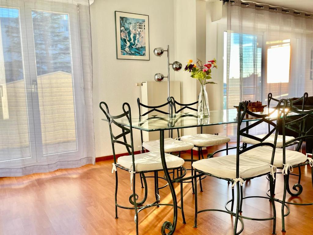 a dining room with a glass table and chairs at City Break Picquecailloux in Bordeaux