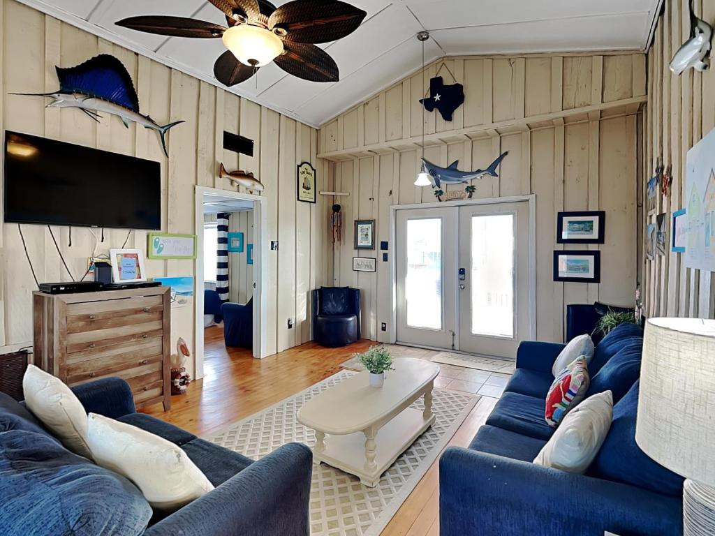 a living room with a blue couch and a table at Flip Flop Beachside in Galveston