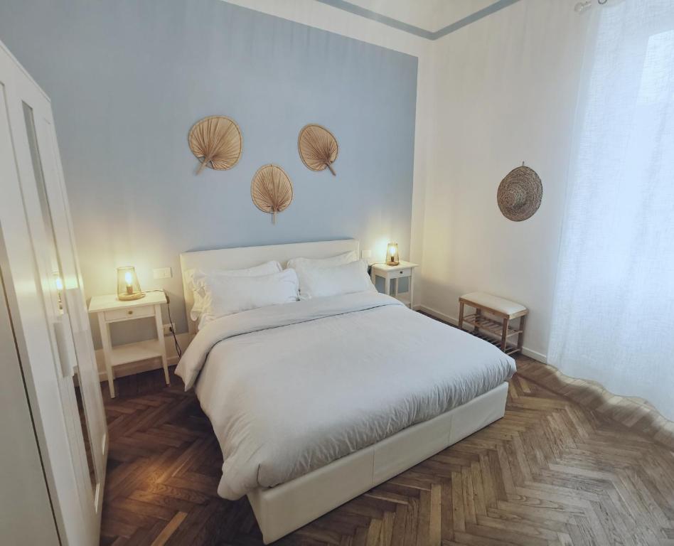 a bedroom with a large white bed and two tables at AZZURRA Ridi Che Ti Passa in Alassio