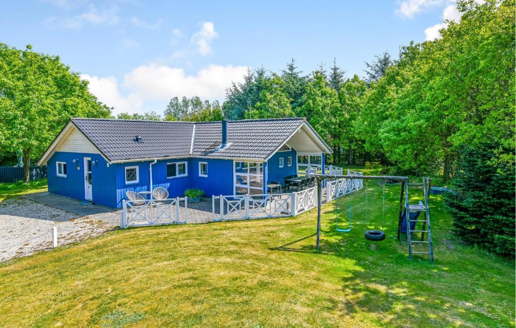 een blauw huis met een speeltuin in een tuin bij Amazing Home In Oksbl With Wifi in Oksbøl