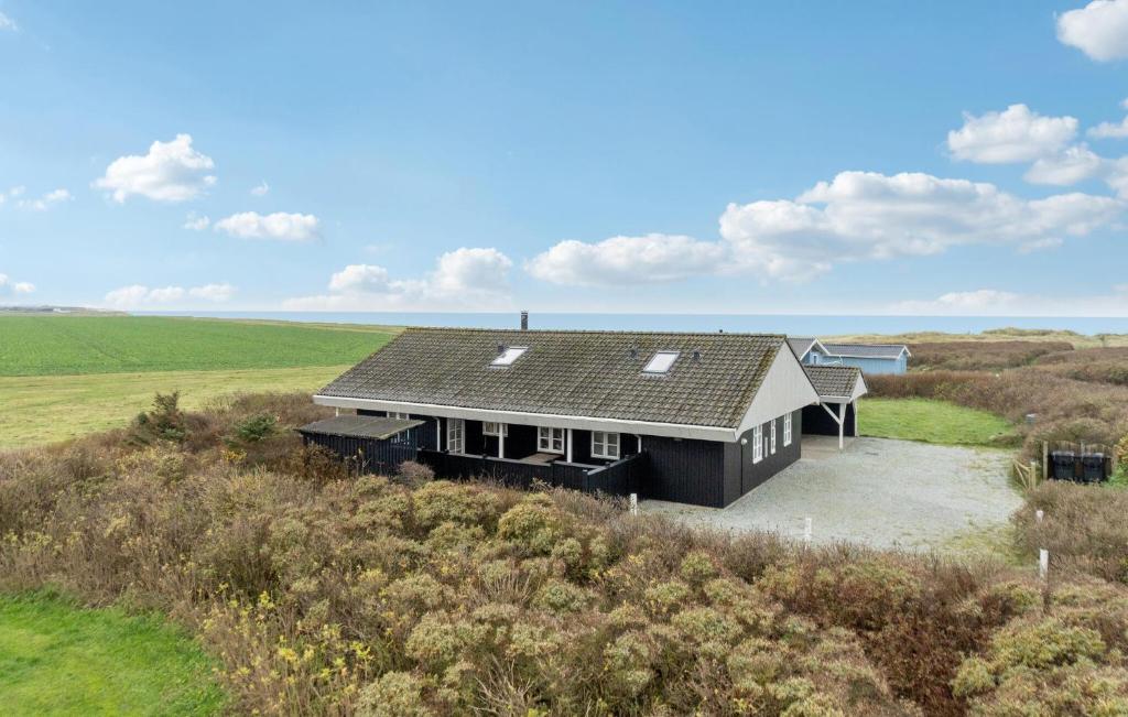 een huis met een zwart dak op een veld bij Stunning Home In Lkken With Wifi in Løkken