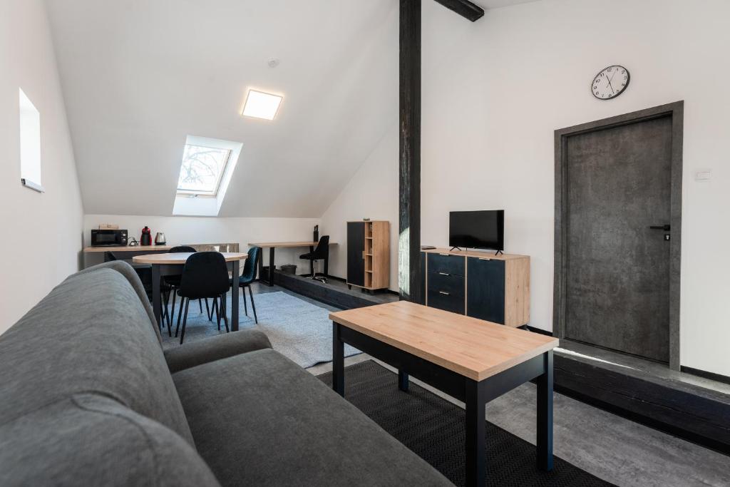 Apartmány Modřany في براغ: غرفة معيشة مع أريكة وطاولة