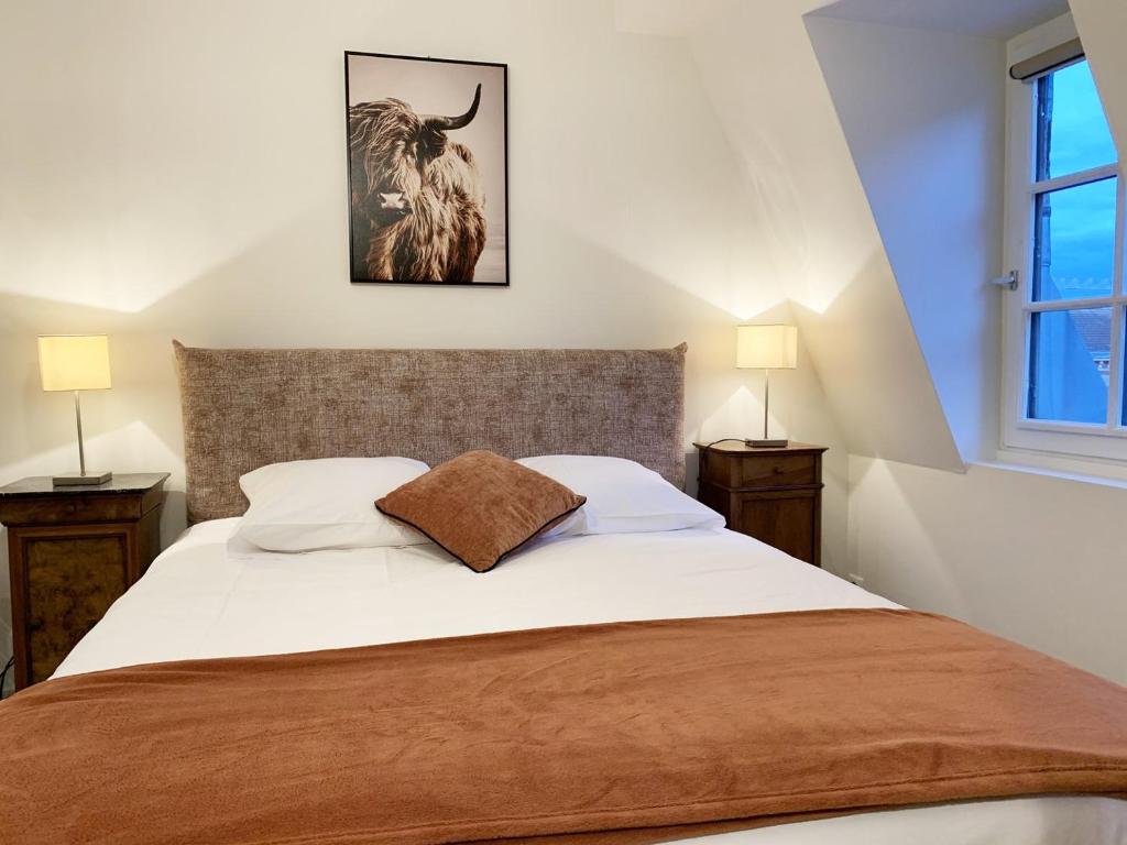 a bedroom with a bed with a bull picture on the wall at Monet - appartement pour 2 personnes in Chartres