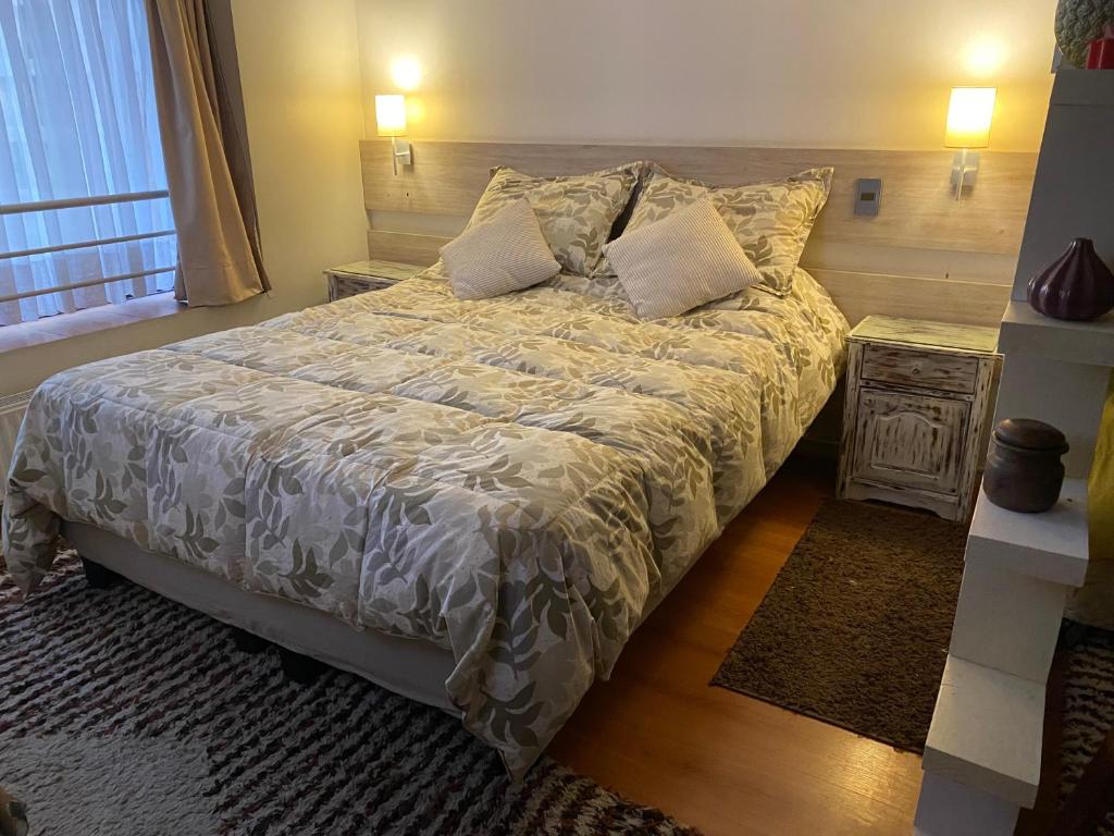 um quarto com uma cama com um edredão branco em Apartamento Amoblado , en el corazón de Providencia em Santiago
