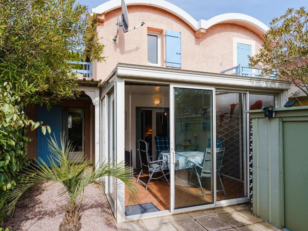 une extension d'une maison avec portes coulissantes en verre dans l'établissement Charmant pavillon 3 chambres avec véranda près plage Grazel – Parking sécurisé - FR-1-409-144, à Gruissan