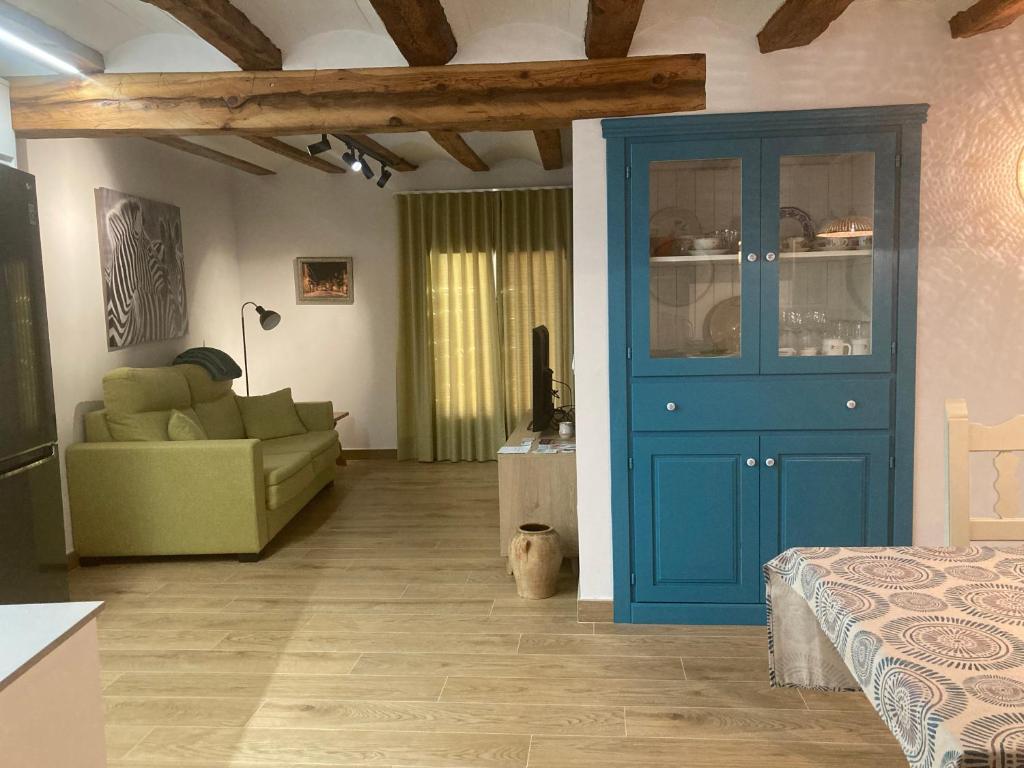 uma sala de estar com uma porta azul e um sofá em Casa Román em Albarracín