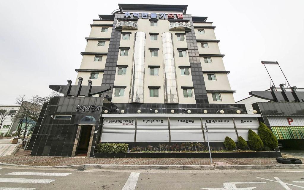 un edificio blanco alto con un letrero. en Cheongju Ochang memory stay en Cheongju