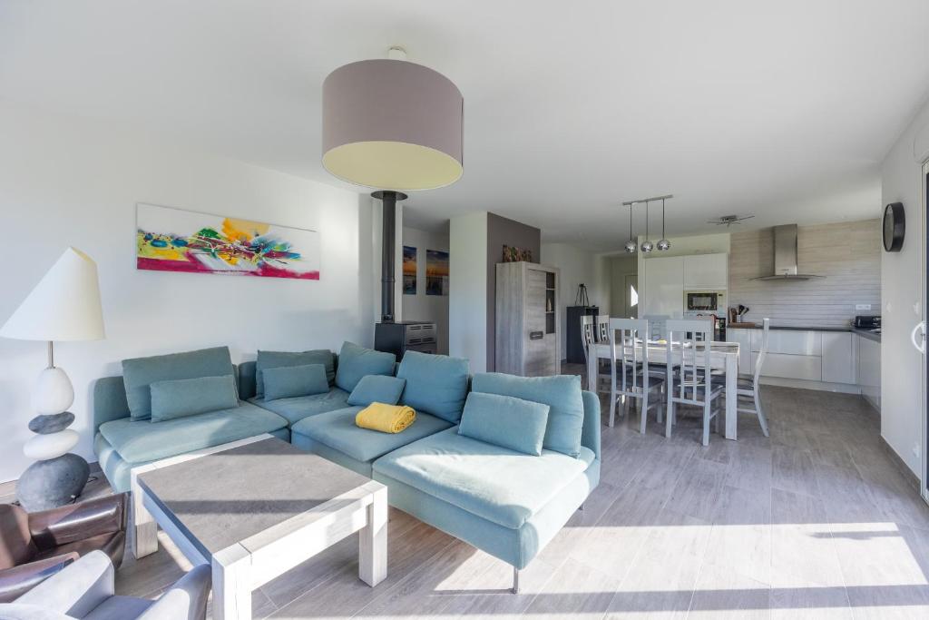 sala de estar con sofá azul y cocina en Les Vignets comfortable holiday home, en Sainte-Honorine-des-Pertes