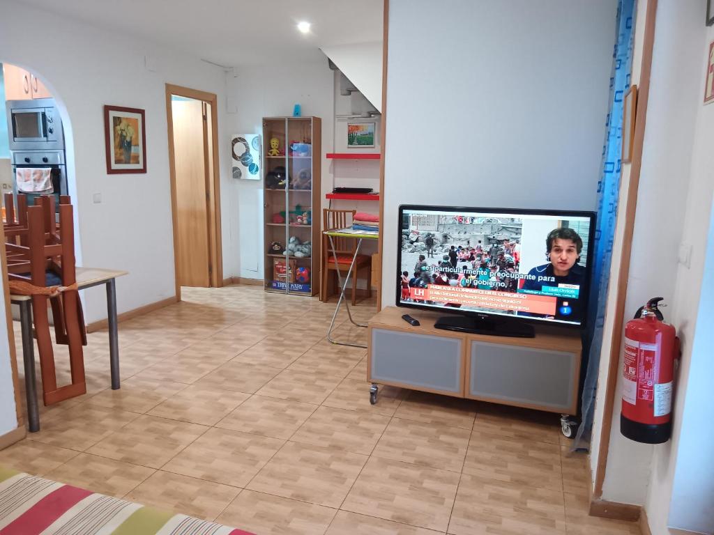 sala de estar con TV de pantalla plana sobre una mesa en Casa Ferrer Barcelona en Hospitalet de Llobregat