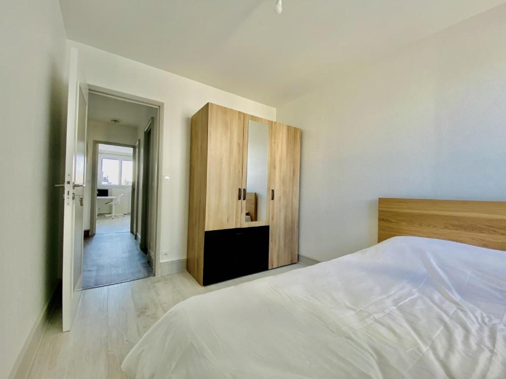 a white bedroom with a bed and a cabinet at Appartement T3 de Standing en Centre-Ville in Joué-lès-Tours