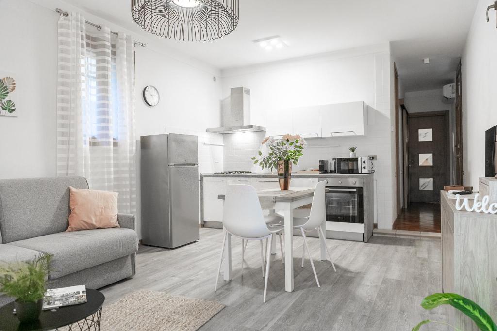 een keuken en een woonkamer met een tafel en stoelen bij Ca' Latina - Cozy home in pieno centro storico in Treviso