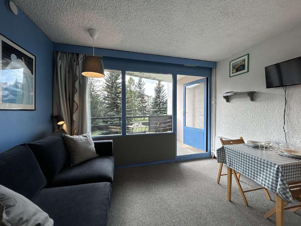 un salon avec un canapé et une table dans l'établissement Confortable studio 2 pers. à Montgenèvre, balcon ouest, bien équipé, parking, options WiFi et linge - FR-1-330D-22, à Montgenèvre