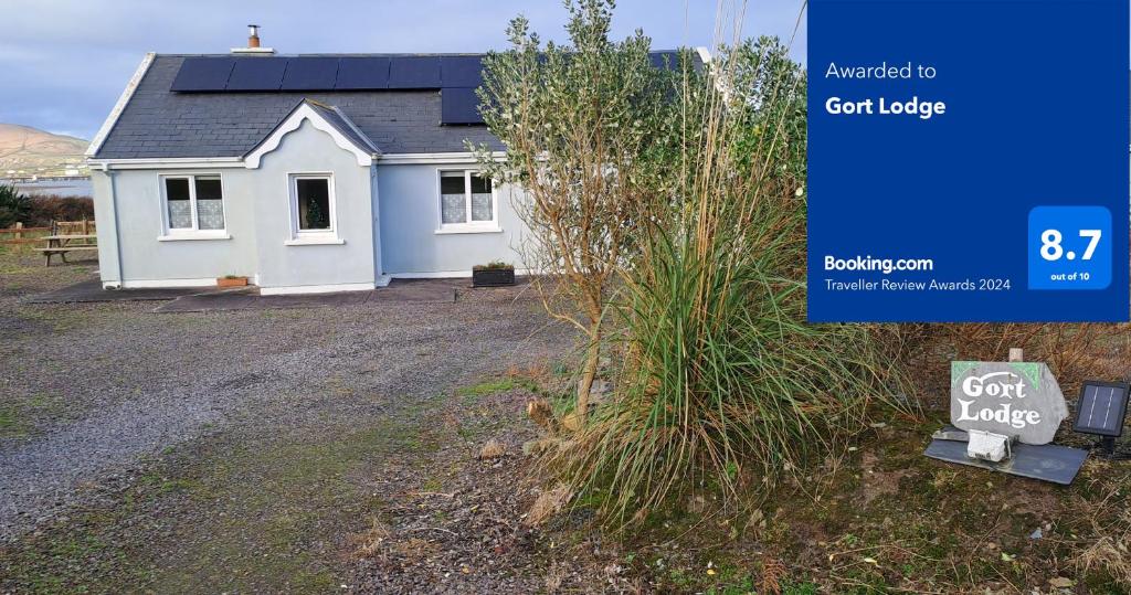 a white house with a sign in front of it at Gort Lodge in Portmagee