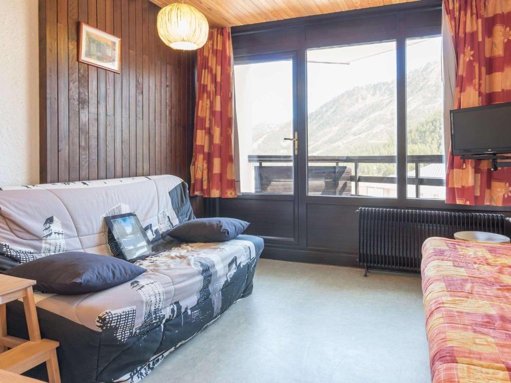 ein Wohnzimmer mit einem Sofa und einem großen Fenster in der Unterkunft Appartement Montgenèvre, 2 pièces, 6 personnes - FR-1-330D-56 in Montgenèvre