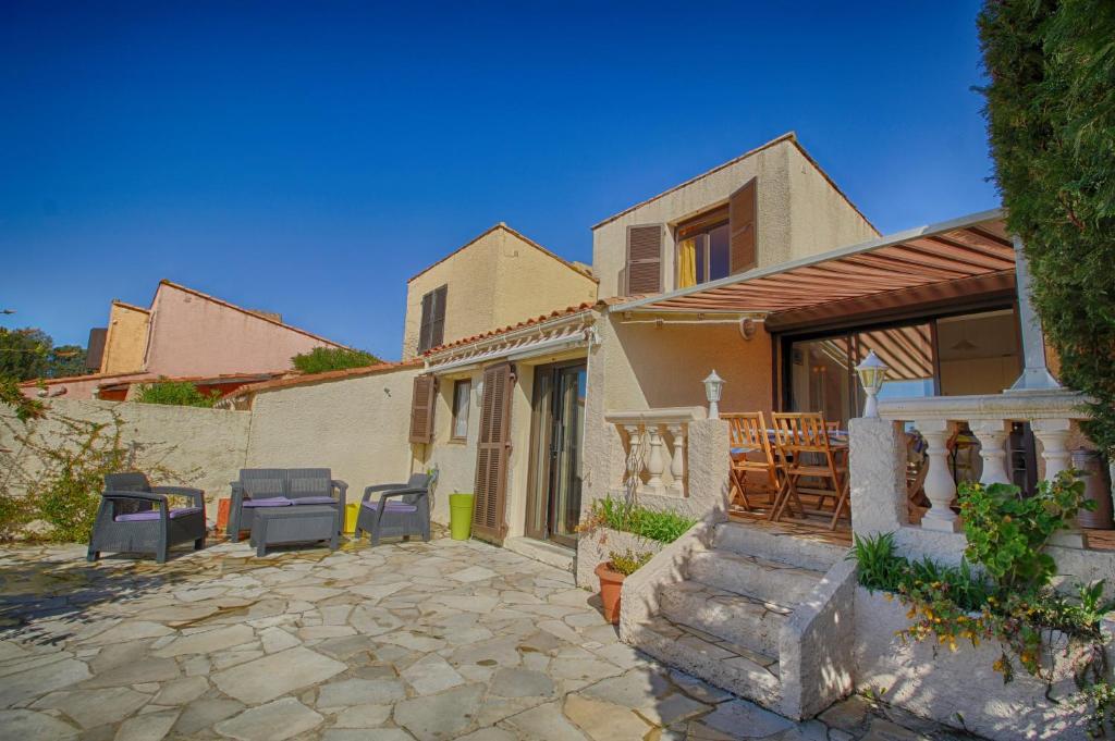 une maison avec des chaises et une terrasse dans l'établissement Villa Terra Bella 2 PORTICCIO, à Porticcio
