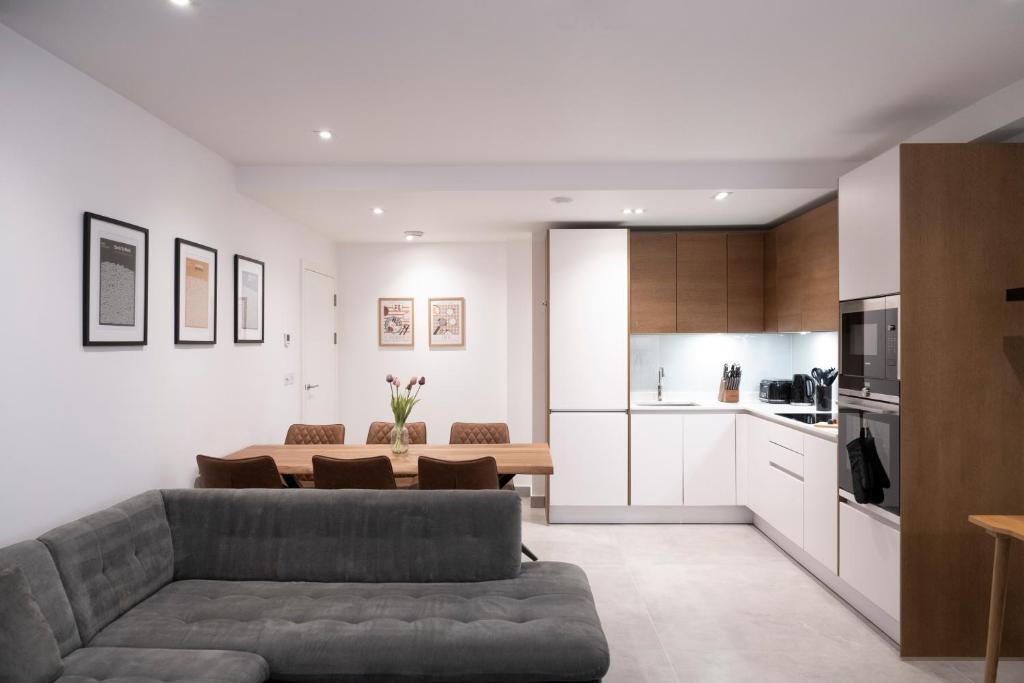 a living room with a couch and a kitchen at Newly Furnished Apt w/ Patios - Hampstead Heath in London