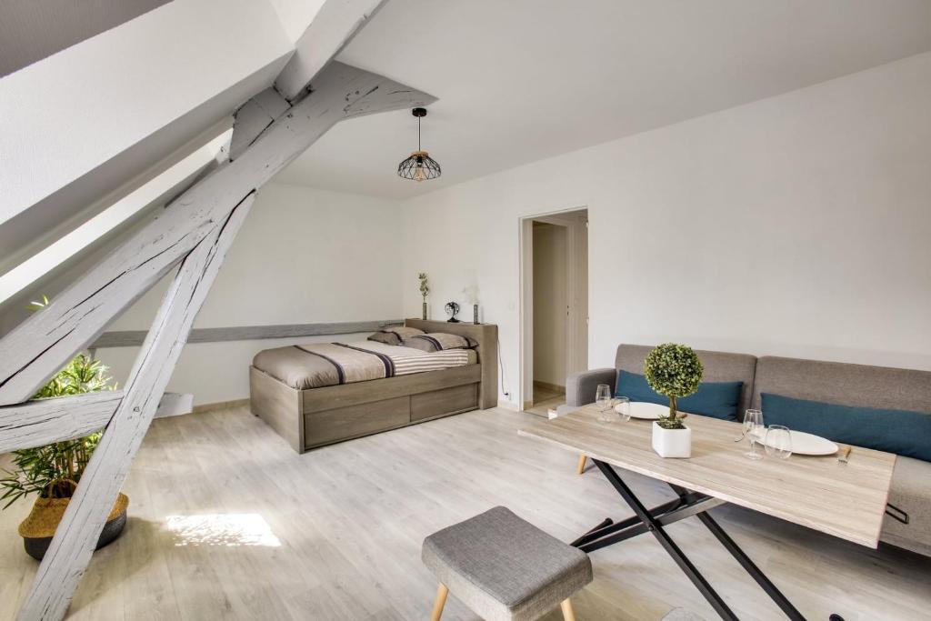 un salon avec un lit et une table dans l'établissement L'Écrin de la Cathédrale, à Chartres