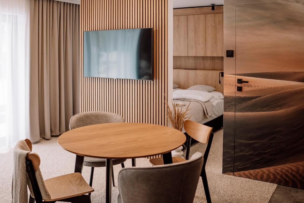 サシノにあるApartamenty Morska 92のテーブル、椅子、ベッドが備わる客室です。