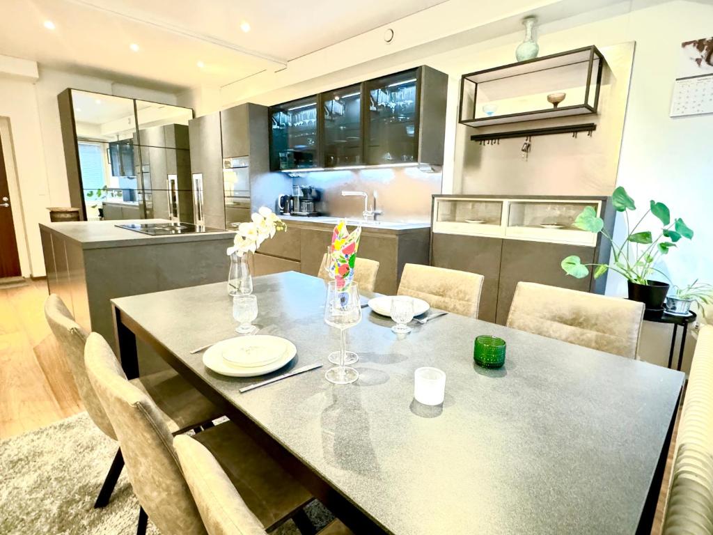 mesa de comedor con sillas y cocina en Turku Central Luxury Modern Cozy Flat 69m2, en Turku