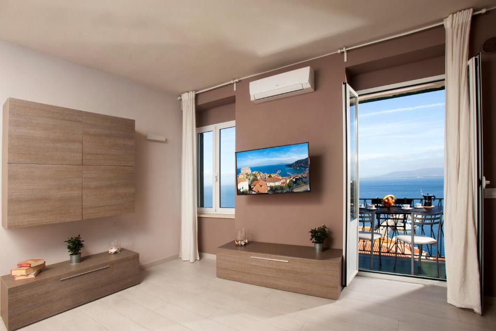 un soggiorno con una grande finestra con vista sull'oceano di La Casa Al Mare a Porto Santo Stefano