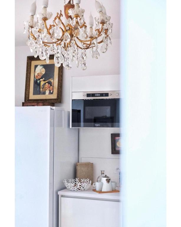 d'un lustre dans la cuisine équipée d'un réfrigérateur. dans l'établissement LA MAISON d'HORTENSE, maison de charme et de caractère, à Toulouse