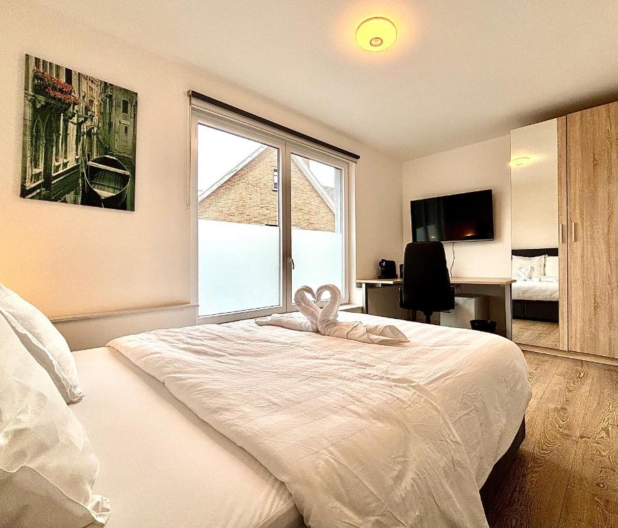 una camera da letto con un grande letto bianco e una finestra di Il Casolare a Beersel